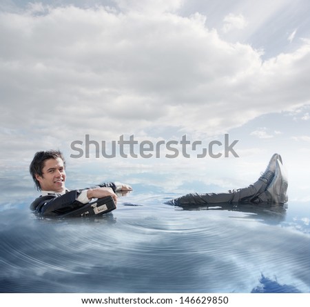 Businessman in the water lying on the back smiling at camera in blue sky background