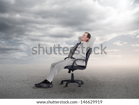 Relaxed businessman sitting on a chair in open desert setting