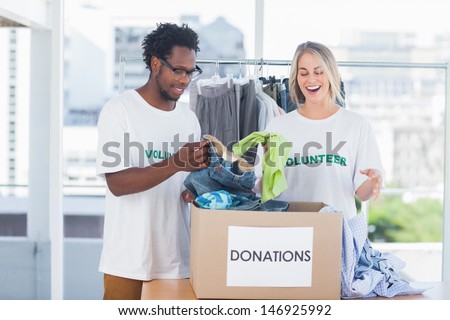 Volunteers looking at a donation box full of clothes