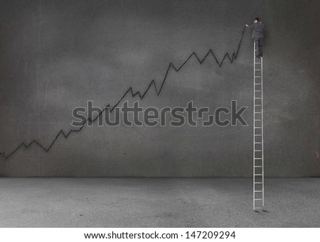 Businessman standing on a giant ladder and writing a black chart on grey wall