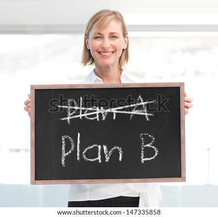 Businesswoman holding a blackboard with plan a and plan b written on it
