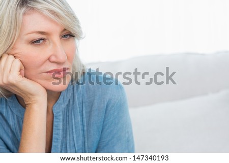 Depressed woman thinking at home on couch