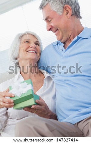 Husband giving a gift to happy wife