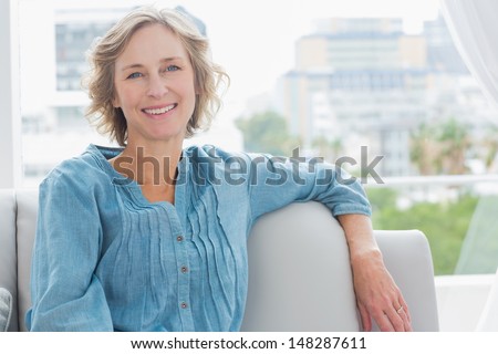 Happy woman relaxing on her couch at home in the sitting room