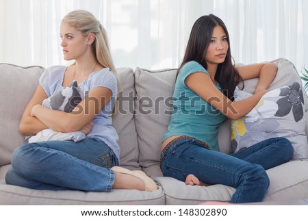 Friends not talking to each other after a fight at home on the couch