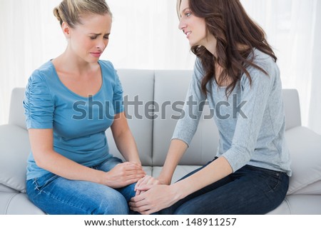 Woman Consoling Her Crying Friend And Sitting On The Sofa