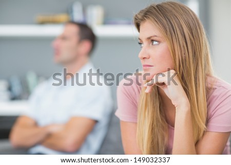 Couple not talking after a dispute on the couch in living room at home