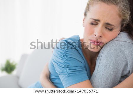 Upset woman being consoled by her friend and closing eyes