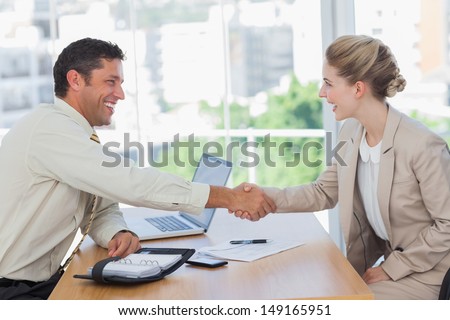 Blonde woman shaking hands while having an interview in office