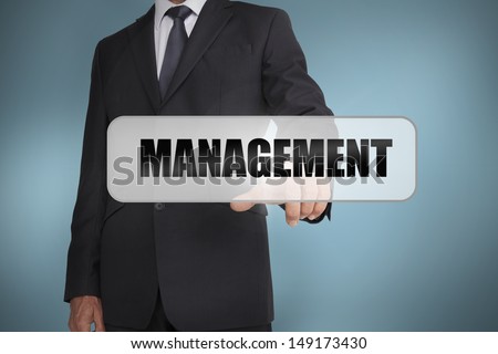 Businessman selecting the word management written on white tag on blue background