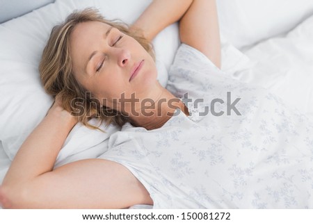 Woman sleeping peacefully in bed in bedroom at home