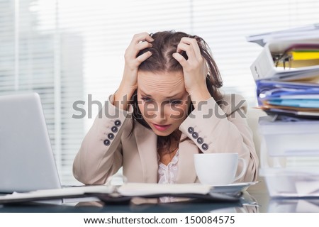 Nervous businesswoman pulling her hair out in her bright office