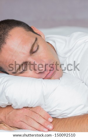 Handsome man sleeping on his pillow at home in the bedroom