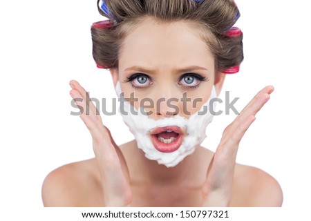 Astonished woman posing with shaving foam on face on white background
