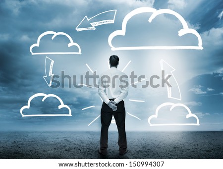 Businessman considering cloud computing graphics in cloudy desert setting