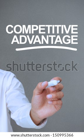 Businessman writing competitive advantage with a marker on grey background