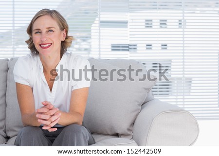 Blonde businesswoman sitting on couch during break time