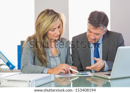 Two content mature business people trying to understand figures at office
