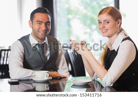 Business people having coffee and looking at camera in a cafe