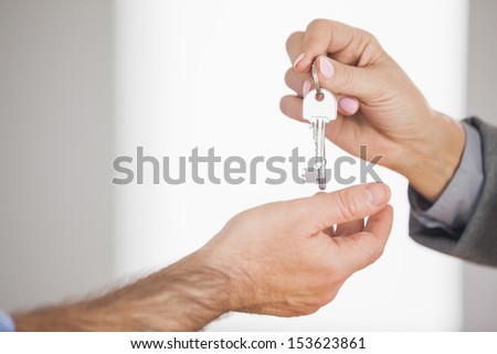 Estate agent giving key to customer in an empty house