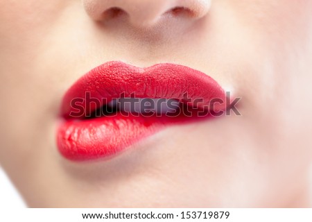 Close up on sensual model biting red lips on white background