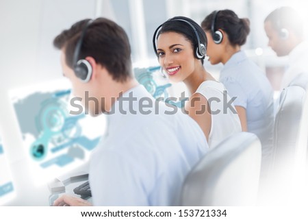 Pretty call center worker using futuristic interface hologram smiling at camera in office