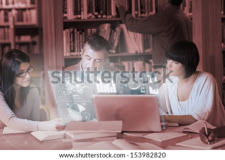 Focused mature students working together on digital interface in university library