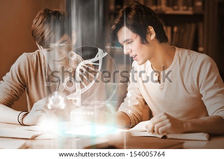 Happy college students analyzing dna on digital interface in university library