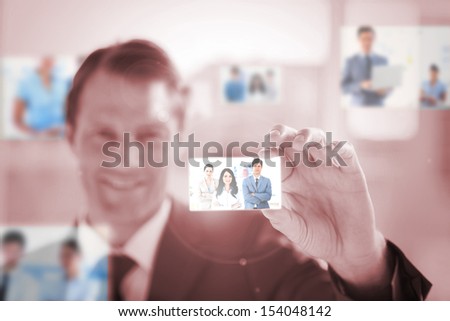 Smiling businessman picking a business team picture on red background
