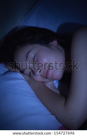 Young asian woman sleeping happily at night at home in bedroom
