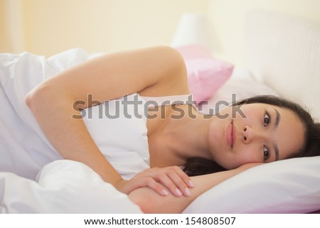 Young asian woman lying in her bed and thinking in bedroom at home