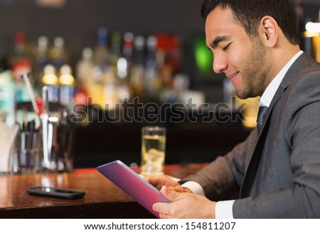 Close up of businessman sitting at bar and reading drinks menu