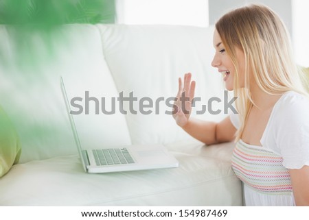 Woman sitting on floor calling with laptop in living room
