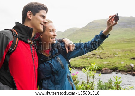Athletic couple on a hike taking a selfie in the countryside