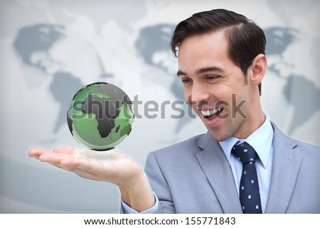Content businessman admiring a green globe on map background