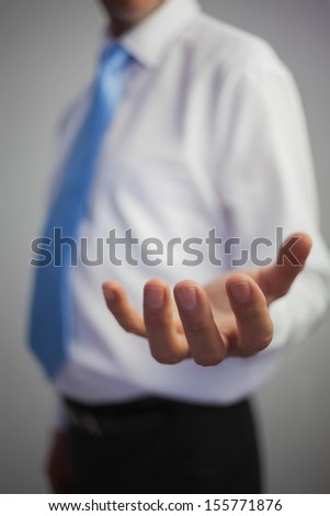 Close up of a casual businessman reaching out on grey background