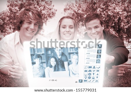 Cheerful college friends watching photos together on digital interface in bright park