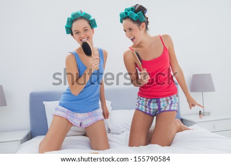 Girls having fun wearing pajama and hair rollers at sleepover