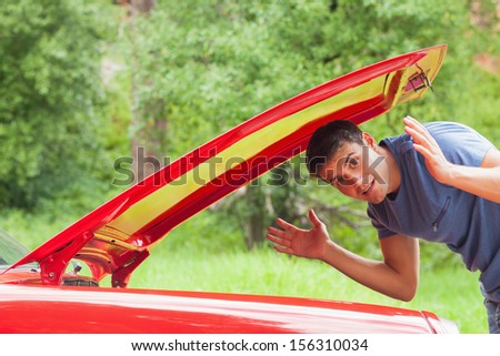 Lost handsome man checking his car engine after breaking down