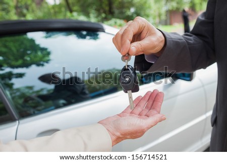 Close up on business man giving his keys to his partner to go to a meeting