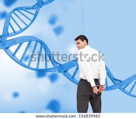 Composite image of businessman wearing handcuffs in front of dna spiral