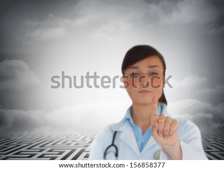 Composite image of young brunette doctor pointing in front of huge maze in background
