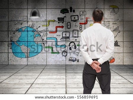 Composite image of businessman turning his back to camera looking at economic illustrations on wall