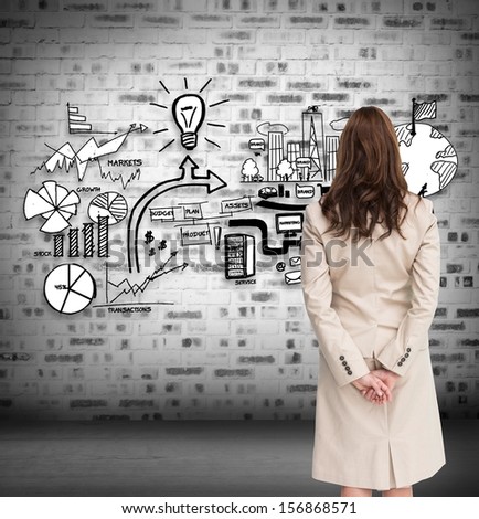 Composite image of rear view of businesswoman crossing hands behind back looking at economic illustrations on grey wall