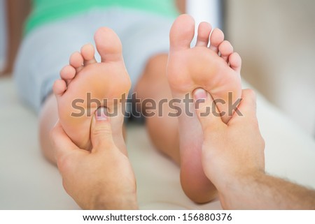 Physiotherapist giving a patient a foot massage in bright office