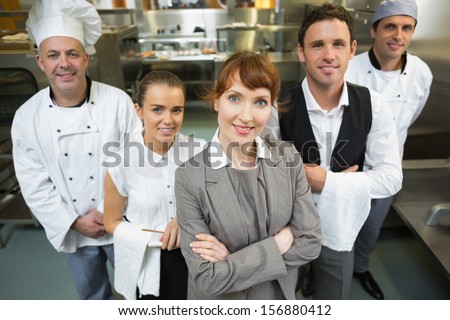 Cute Female Manager Posing With The Staff In A Modern Kitchen