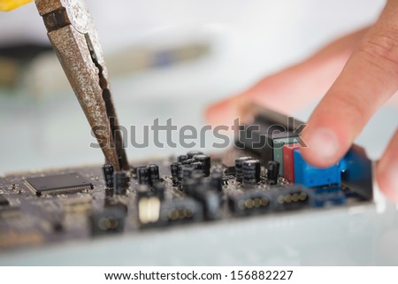 Extreme close up of pliers repairing hardware in bright office