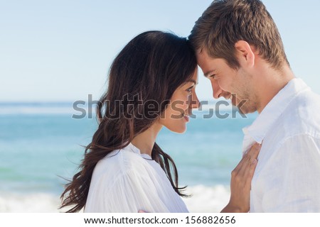 Attractive Couple Embracing On The Beach On A Sunny Day
