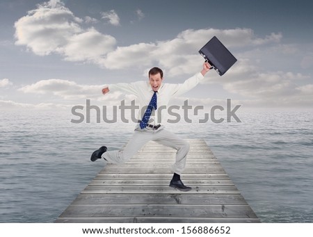 Composite image of cheerful jumping businessman with his suitcase on bridge in ocean