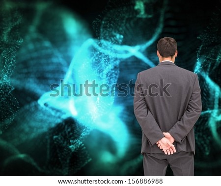 Composite image of businessman standing with hands behind back on black background glowing blue